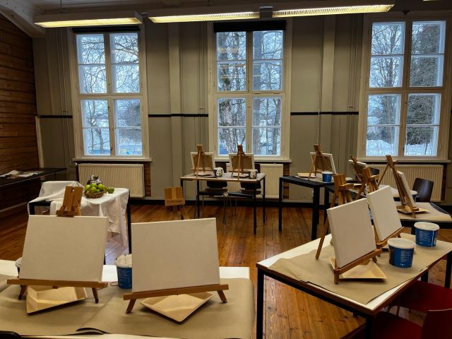 maalausalustoja luokassa pöydille ryhmiteltyinä