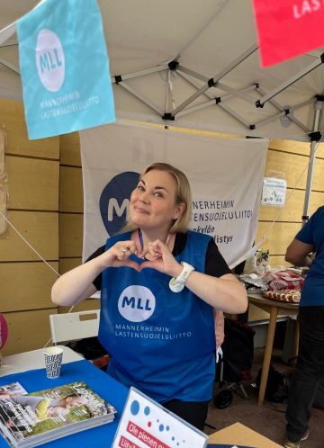 Nainen ständillä esittelemässä MLL:n toimintaa