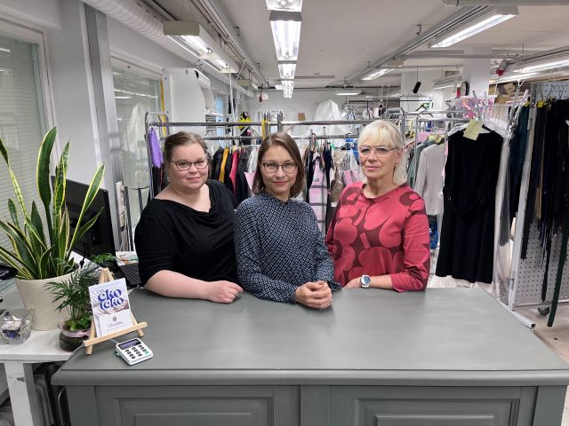 Kolme naista pöydän takana ompelimon tiloissa