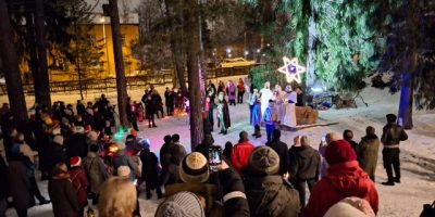 Ihmisiä kokoontuneena pihalle katsomaan esitystä talvisessa säässä