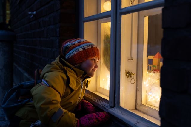 Tyttö kurkistaa sisään ikkunasta