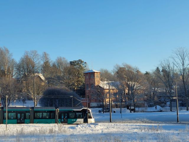 talvinen maisema, jossa näkyy pikaratikka vasemmalla ja keskellä Oulunkylän Seurahuone