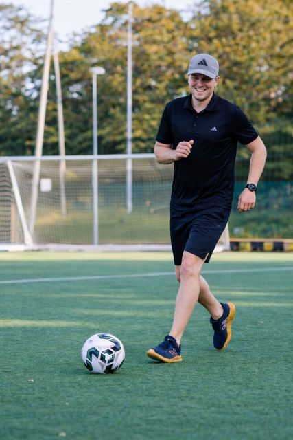 mies juoksemassa kohti jalkapalloa kentällä
